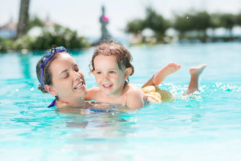 Swim instructor helping a child in the pool