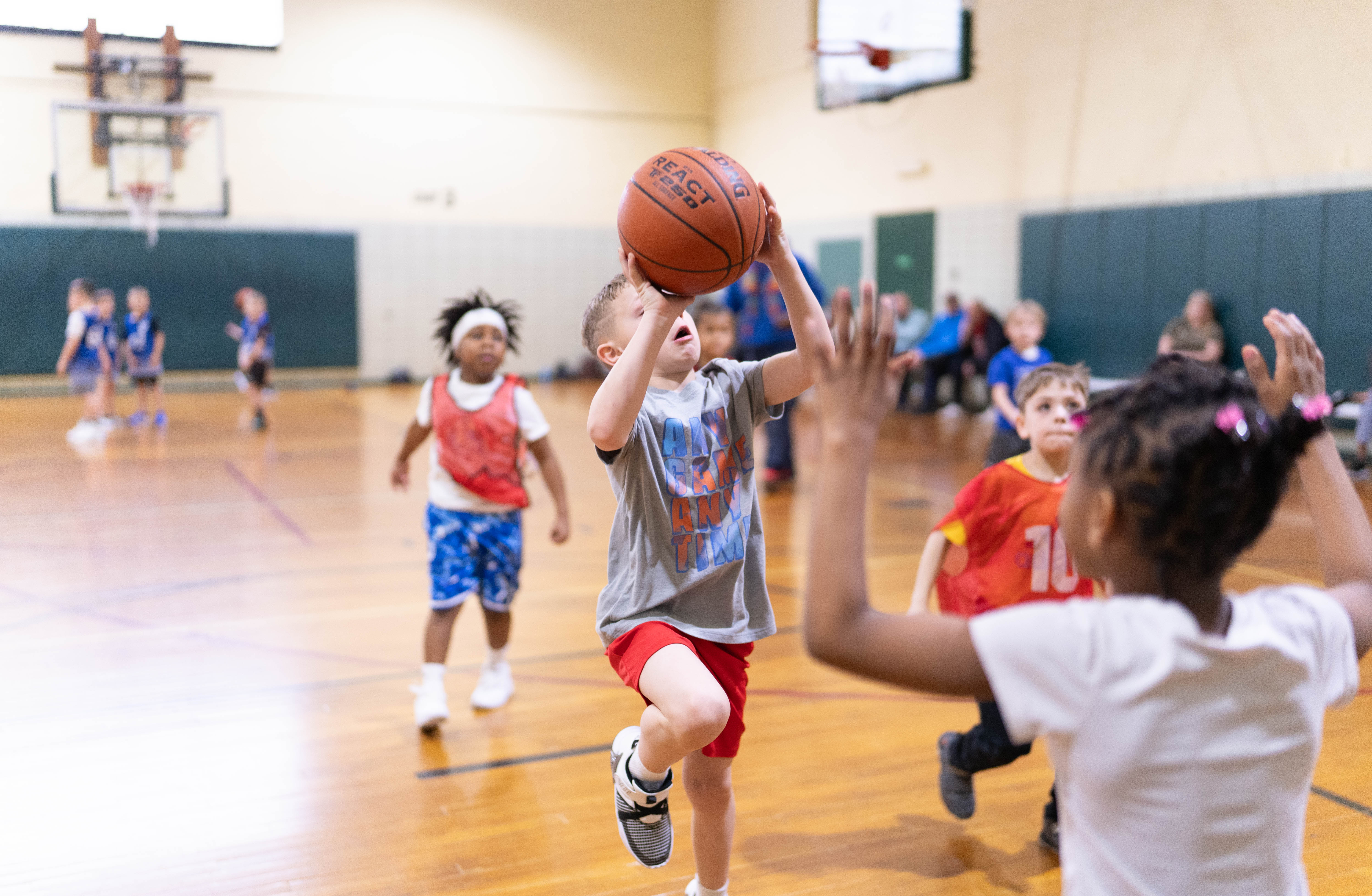 A young basketball player shooting while teammates defend