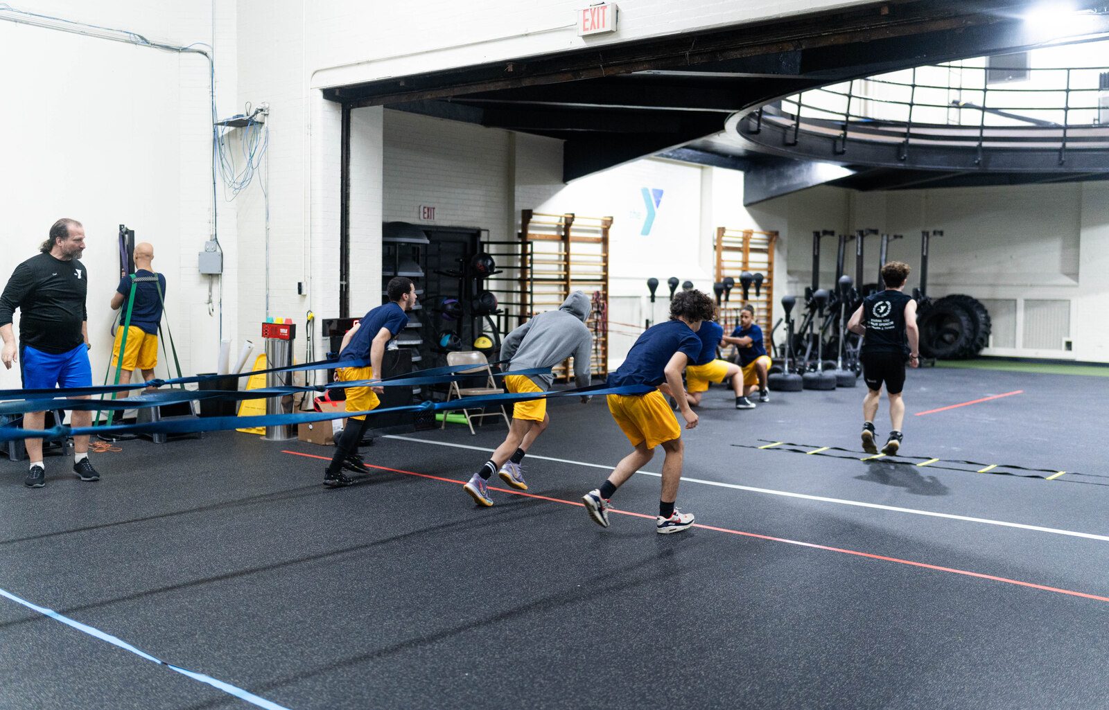 Teammates practicing resisted running and agility drills at the Athletic Performance Center