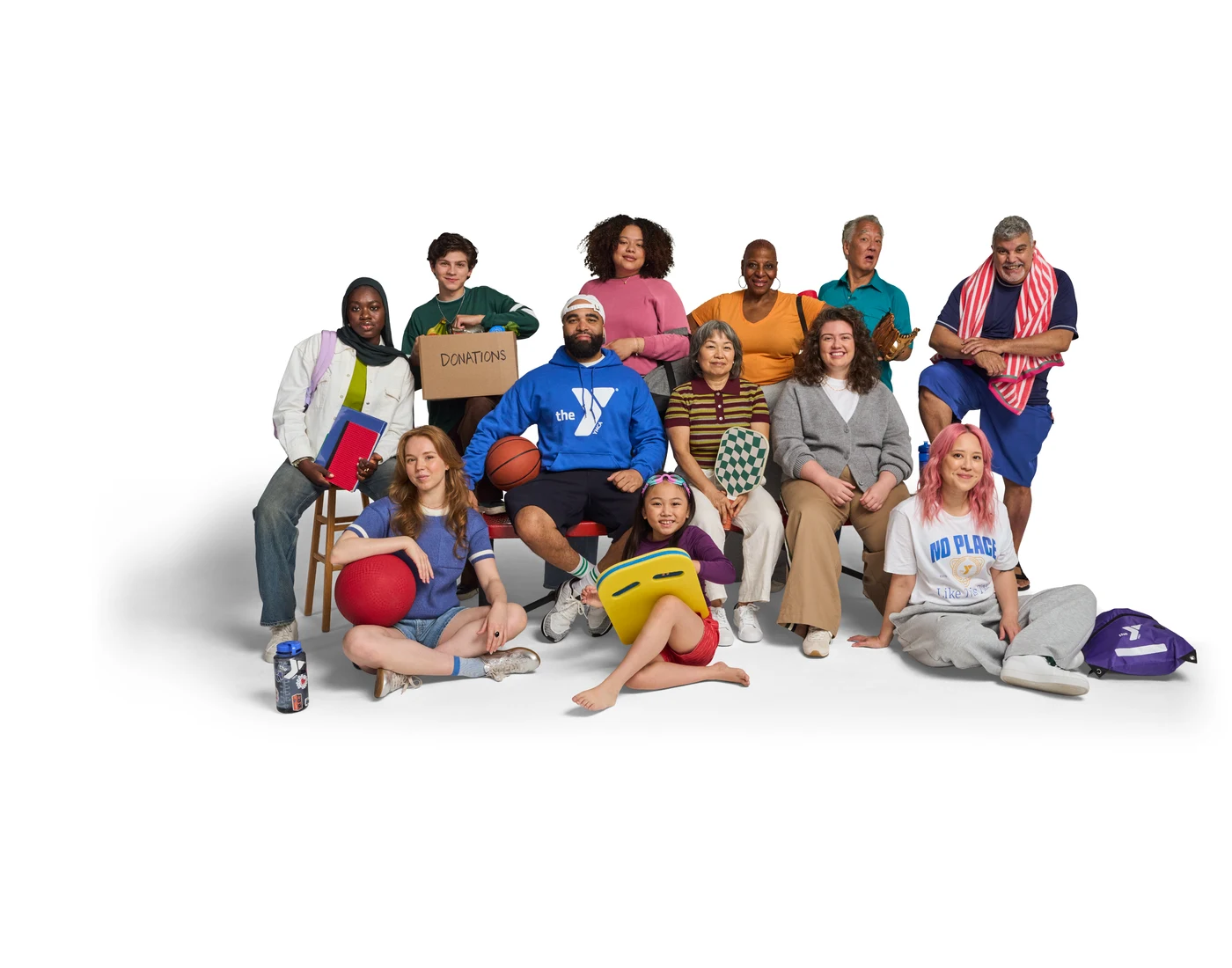 YMCA community members of different ages gathered with sports and recreation equipment